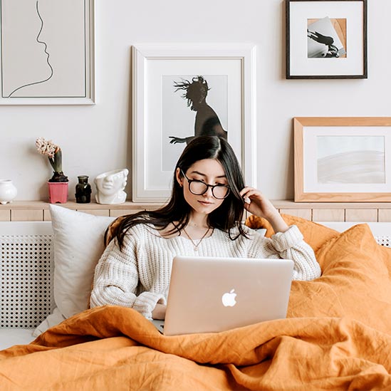 WOman Working on Laptop in Bed Woman Working on Laptop in Bed